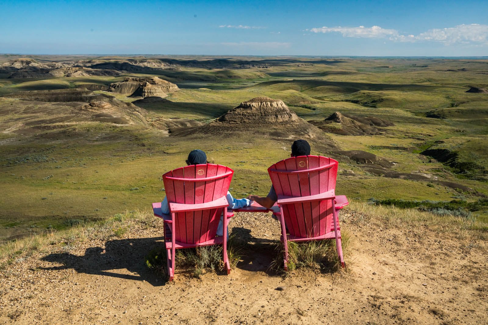 sitting-at-the-Parks-Canada-red-adirondack-chairs-at-Ta-Sunka-Watogla-in-Grasslands-National-Park-East-Block-along-Badlands-Parkway-in-Saskatchewan